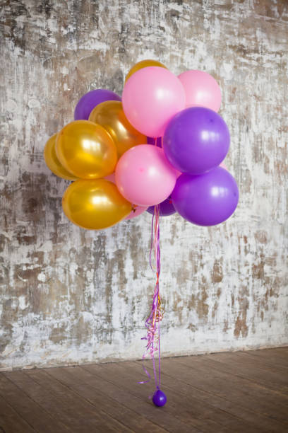 istock Bright balloons bunch against a textured wall 690050692