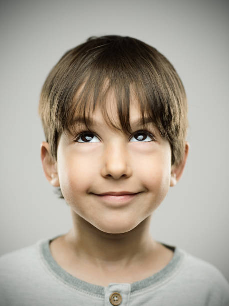 little boy looking up on gray background - carefree joy children only pre adolescent child imagens e fotografias de stock