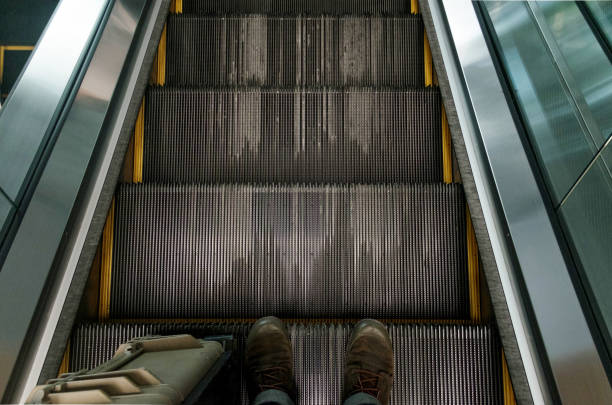 istock Top view of old boots on escalator steps. 690054786