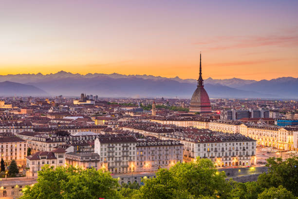 paesaggio urbano di torino (torino) al crepuscolo con colorato cielo lunatico. la mole antonelliana che sovrasce la città illuminata sottostante. - torino foto e immagini stock