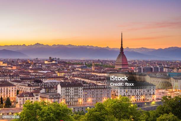 Cityscape Of Torino At Dusk With Colorful Moody Sky The Mole Antonelliana Towering On The Illuminated City Below Stock Photo - Download Image Now