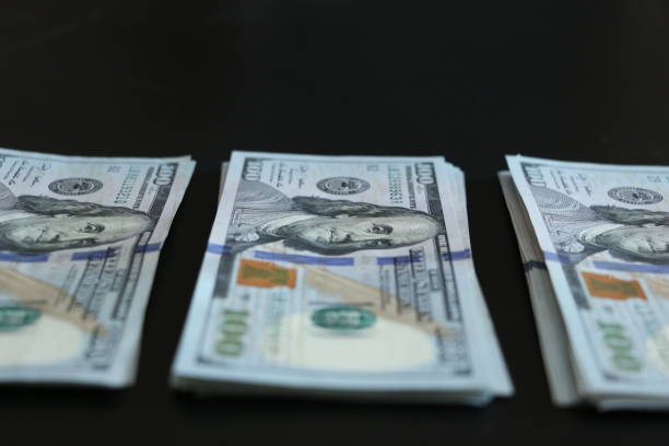 istock Bunch of 100 dollar bills on black background. 690073320