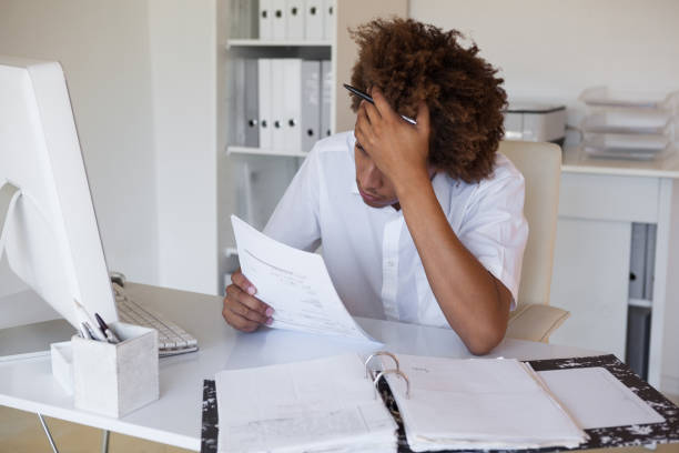 istock Casual stressed businessman going over paperwork at his desk 690081104