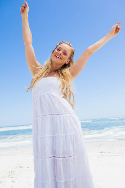istock Pretty carefree blonde smiling at camera on the beach 690084030