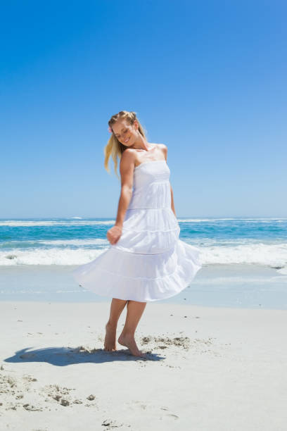 istock Pretty carefree blonde standing on the beach 690084378