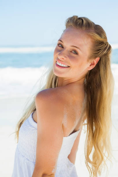 istock Pretty carefree blonde smiling at camera on the beach 690084448