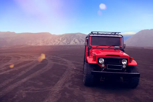 A red off-road vehicle in open space.