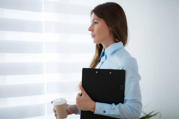 istock Businesswoman drinking coffe at the office window 690110348