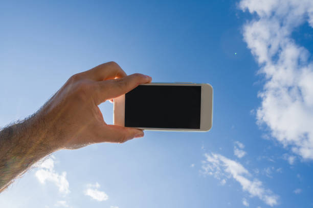 istock Human hand taking photo of sky 690110936