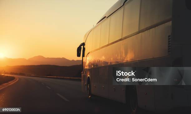 White Bus Driving On Road Towards The Setting Sun Stock Photo - Download Image Now - Bus, Travel, Road