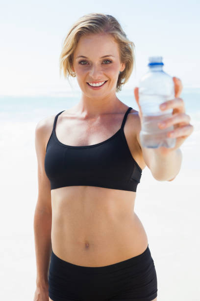 istock Fit blonde drinking water on the beach 690130838