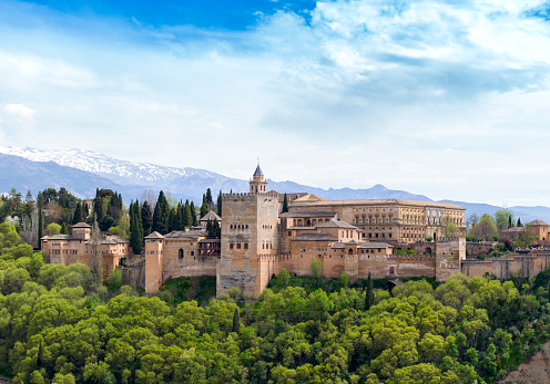 The Alhambra of Granada, the main landmark of Granada and one of the most famous monuments of Islamic architecture in the world. Behind rise up the snow-capped mountains of the Sierra Nevada.