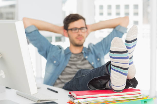 istock Relaxed casual young man with legs on desk 690134656