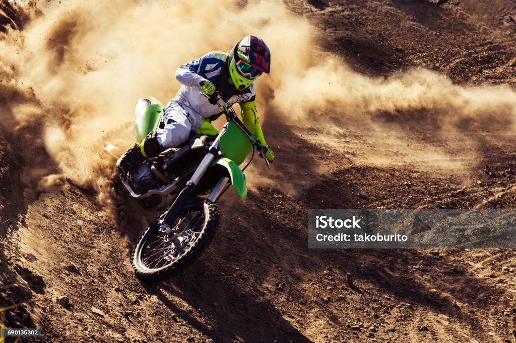 Professional dirt bike rider Motocross rider creates a large cloud of dust and debris Motocross Stock Photo