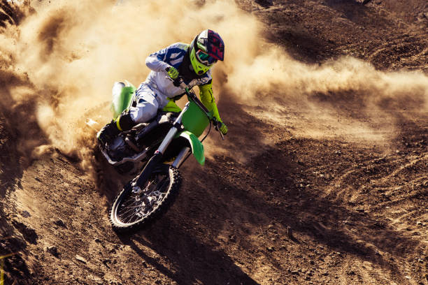Professional dirt bike rider Motocross rider creates a large cloud of dust and debris motorcycle racing stock pictures, royalty-free photos & images