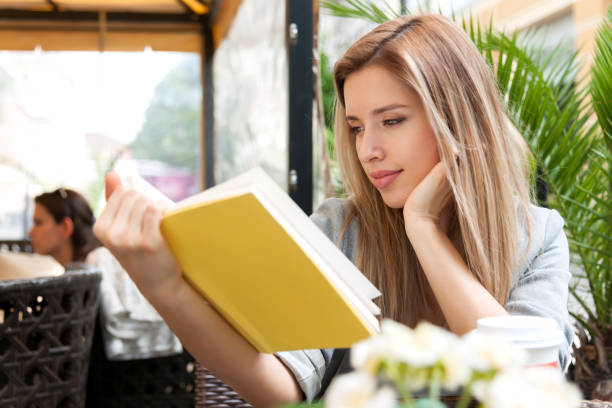 istock Girl Reading Book in Cafe 690135380