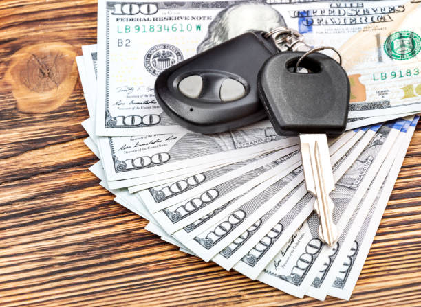 istock Car keys with money on the table. 690148716