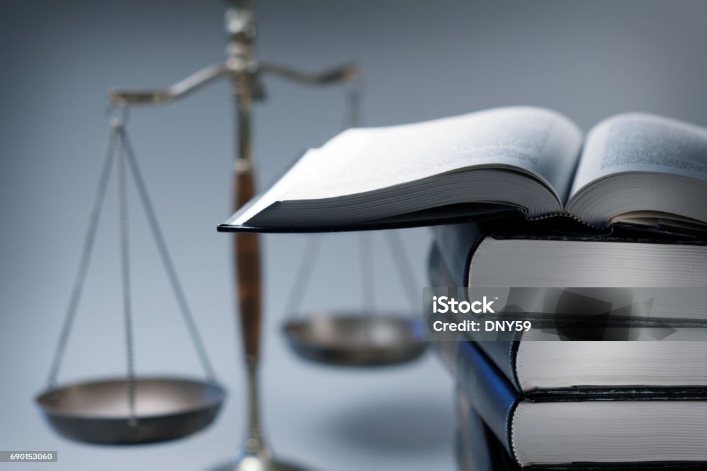 Stapel von Gesetzesbücher vor Waage der Gerechtigkeit - Lizenzfrei Justizwesen Stock-Foto