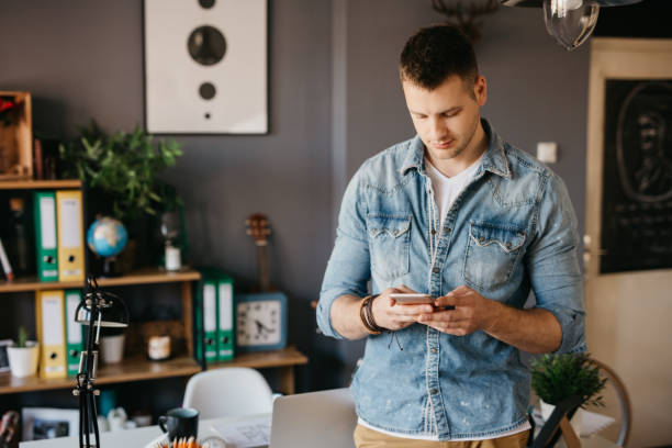 istock Handsome millennial is posting a feed on social media 690153164