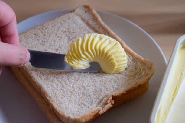 istock spreading margarine butter onto bread 690154392