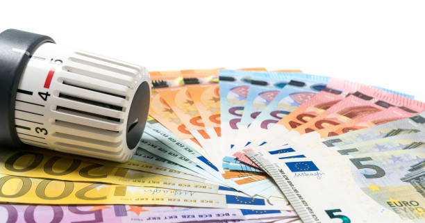 istock Heating thermostat with money, expensive heating costs concept 690161950