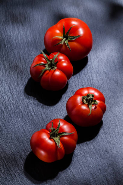 tomates da sobre fundo preto ardósia - tomato heirloom tomato vegetable isolated - fotografias e filmes do acervo