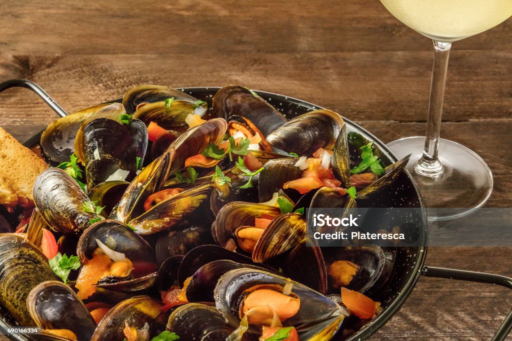 Sartén de marinara mejillones con vino blanco en fondo rústico - Foto de stock de Mejillón libre de derechos