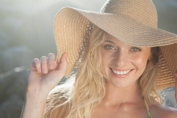 istock Gorgeous blonde in straw hat smiling at camera on beach 690169570