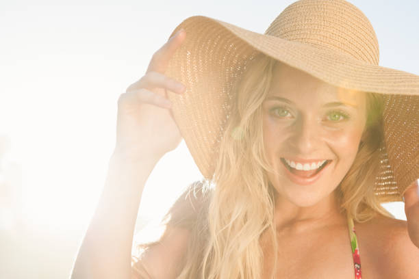 istock Gorgeous blonde in straw hat smiling at camera on beach 690169604