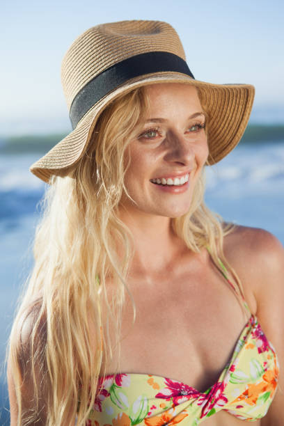 istock Gorgeous blonde in straw hat smiling on beach 690169668