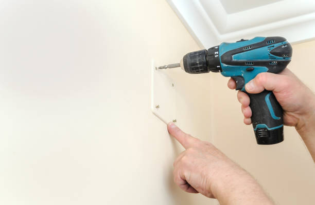 istock Electrician is fixing the lid on the switching box. 690169914