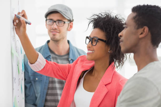 istock Artists in discussion in front of whiteboard 690174128