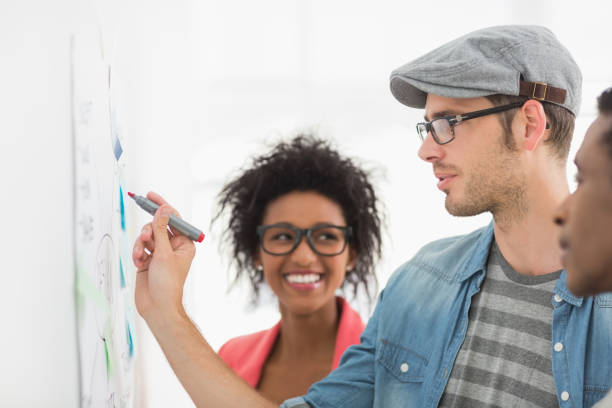 istock Artists in discussion in front of whiteboard 690174154