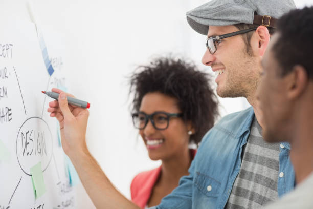 istock Artists in discussion in front of whiteboard 690174156