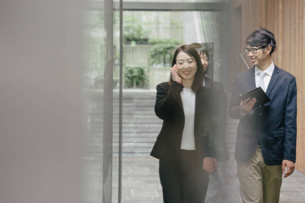 istock Japanese business people walking through office 690177084