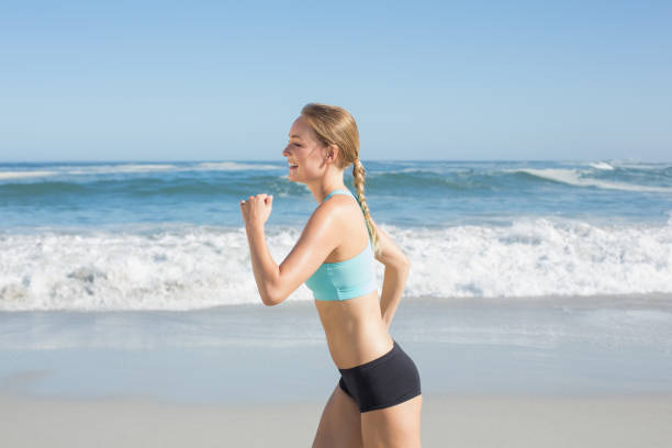 istock Fit blonde jogging on the beach 690183472