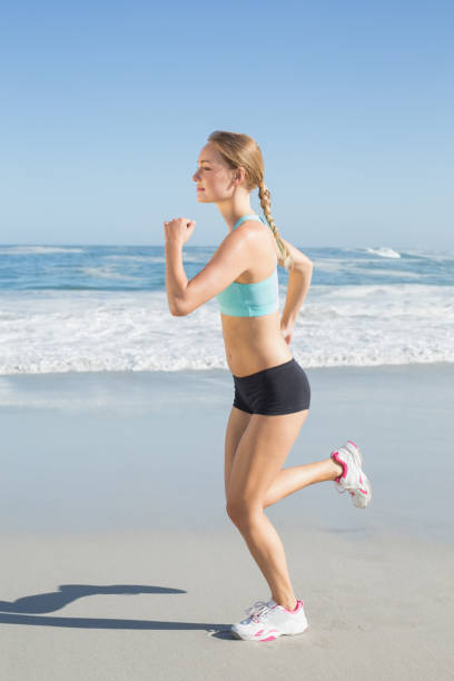 istock Fit blonde jogging on the beach 690183478