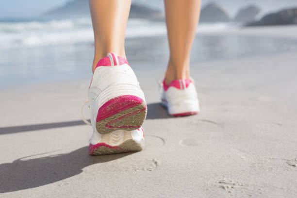 istock Fit woman walking on the beach 690183826