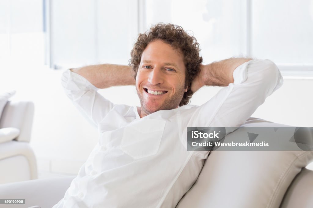 Portrait of a well dressed young man at home Portrait of a well dressed relaxed young man sitting on sofa in the house 30-39 Years Stock Photo
