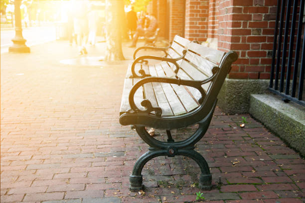 istock Black park bench with sunlight at sidewalk in boston. 690191426