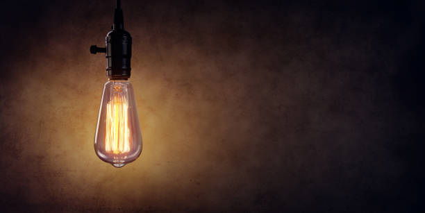 istock Vintage Hanging Light Bulb Over Dark Wall 690202206