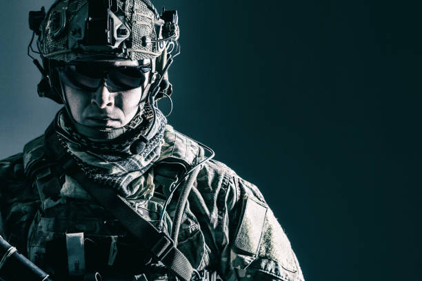 US Army Ranger close-up Elite member of US Army rangers in combat helmet and dark glasses. Studio shot, dark black background, looking at camera, dark contrast military uniform stock pictures, royalty-free photos & images