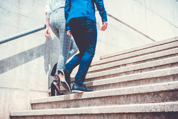istock Rear view of two well dressed people going up the stairs 690206414