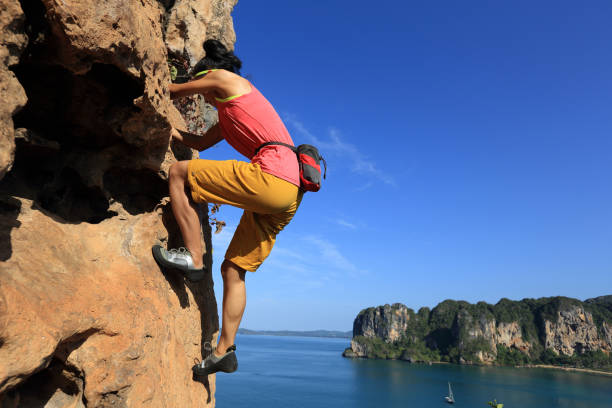 istock young woman rock climber climbing at seaside cliff 690215874