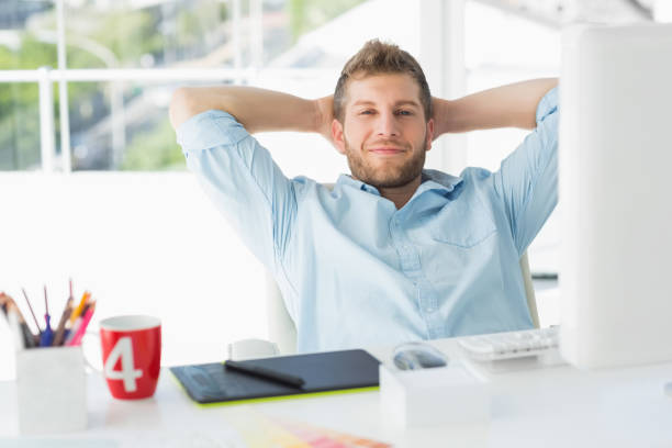 istock Designer relaxing at his desk smiling at camera 690216688