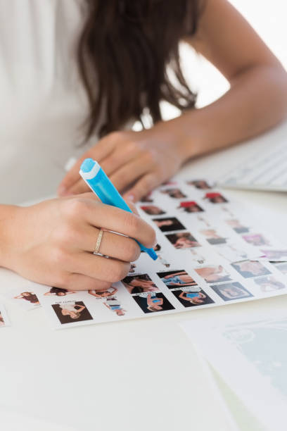 istock Editor working at desk marking a contact sheet 690218700