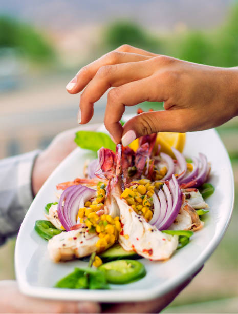 istock Picking up a shrimp from a seafood plate 690221038
