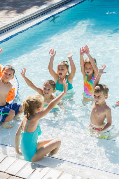 istock Multi-ethnic group of children playing in swimming pool 690223382