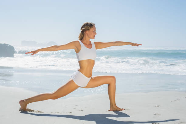 istock Gorgeous blonde in warrior pose by the sea 690223750