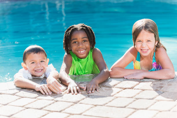 istock Multi-ethnic children hanging on side of swimming pool 690224022